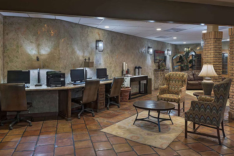 Business center with three computers beside a seating area